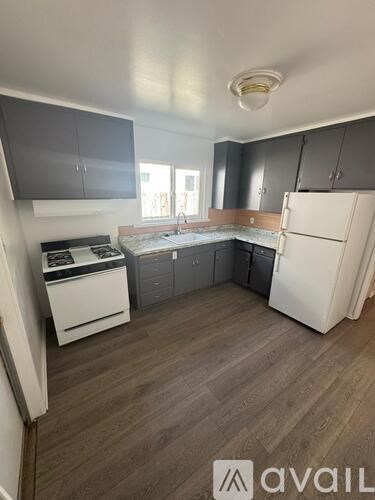 A kitchen with a white fridge, dishwasher, and stove.