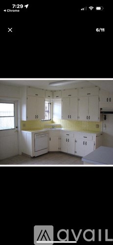 A kitchen with white cabinets and a yellow backsplash.