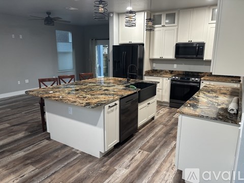 A kitchen with a granite countertop and wooden flooring.