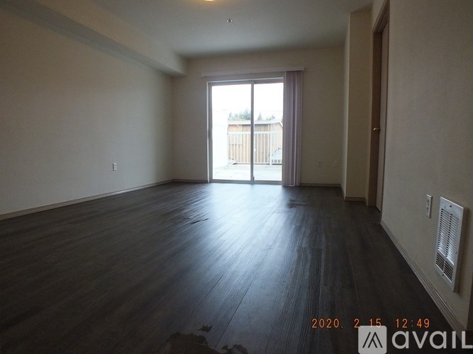 A room with wooden flooring and a large window.