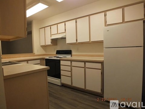 A kitchen with white cabinets and a black dishwasher.