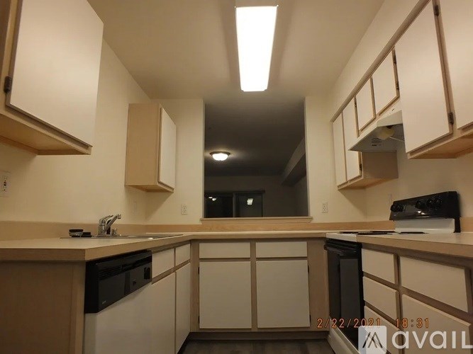 A kitchen with black appliances and wooden cabinets.