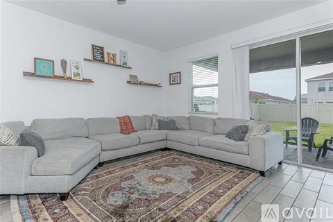 A living room with a grey sectional sofa and a rug.