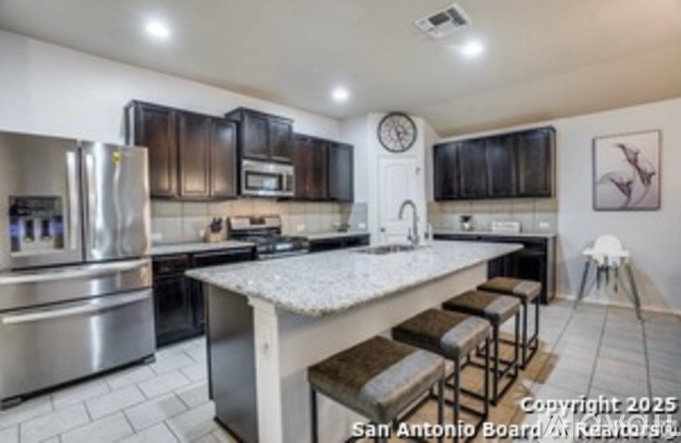 A kitchen with a stainless steel refrigerator, microwave, and oven.