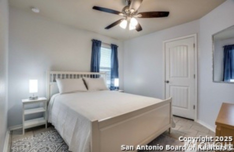 A bedroom with a bed, nightstand, and window.