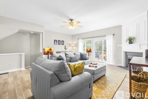 A living room with a grey couch and a yellow rug.