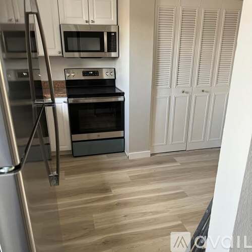 A kitchen with a stove, microwave, and refrigerator.