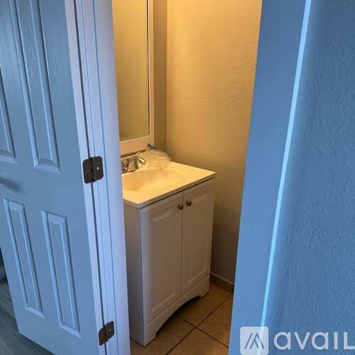 A white cabinet with a sink is in a room.