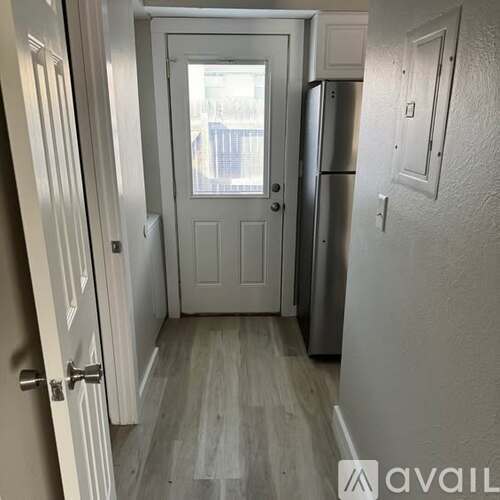 A white door with a window in the middle of a room.