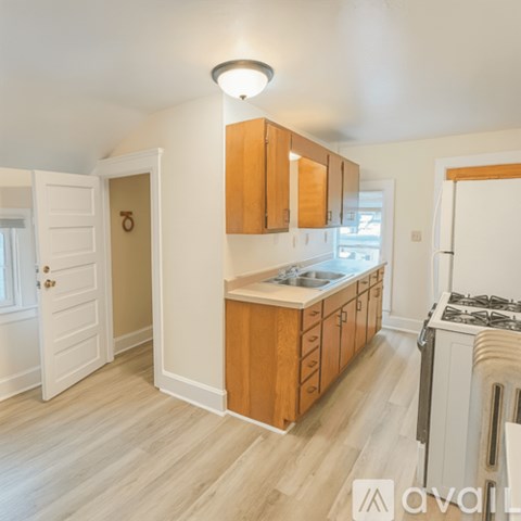 A kitchen with wooden cabinets and a white stove top oven.