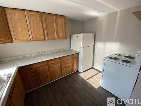 A kitchen with wooden cabinets and a white fridge.