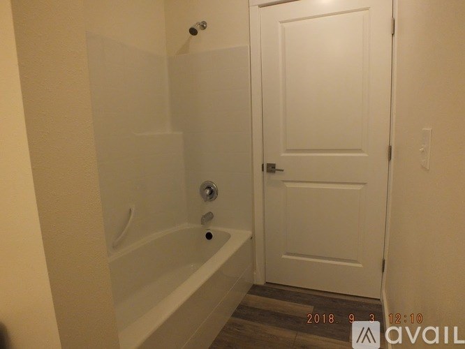A bathroom with a white tub and a white door.