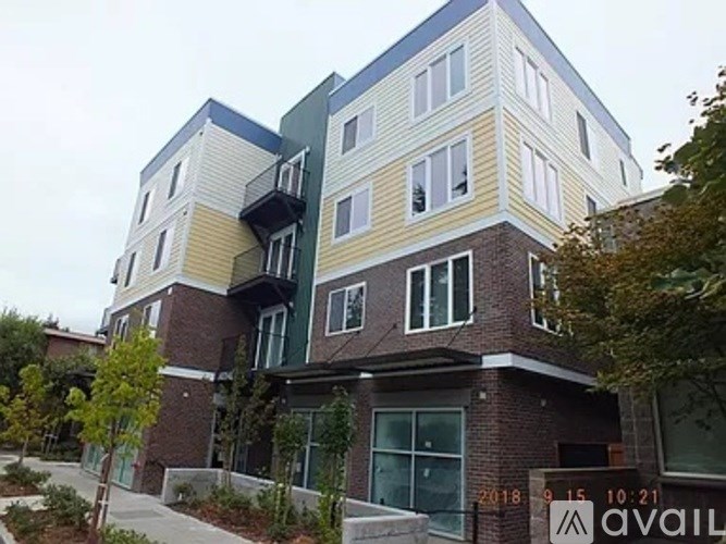 A modern multi-story building with balconies and a mix of brick and panel exterior walls.