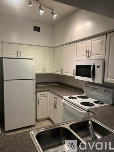 A kitchen with white cabinets and appliances.