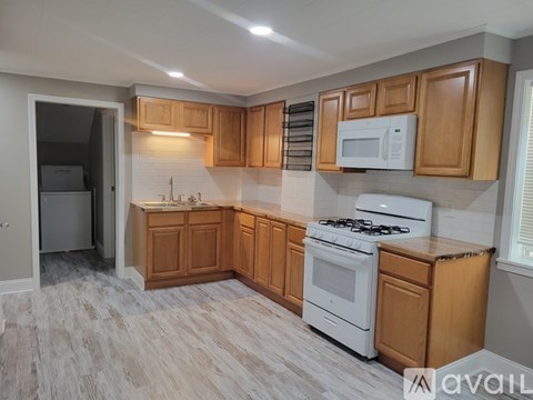 A kitchen with wooden cabinets and white appliances.