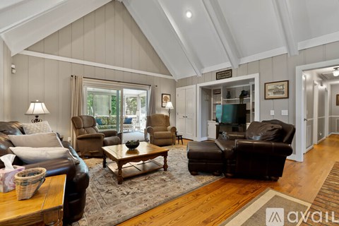 A living room with a brown leather couch and a wooden coffee table.