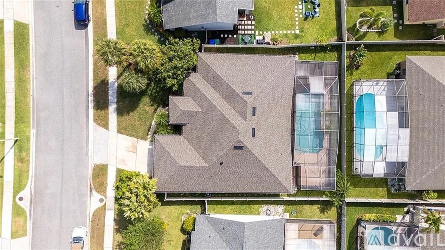A bird's eye view of a residential area with houses and a swimming pool.