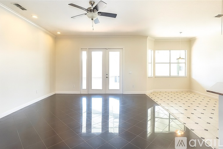 A spacious room with a ceiling fan and a tiled floor.