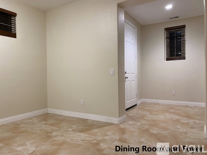 A dining room with a tiled floor and a white door.