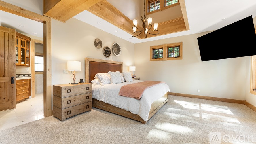 A bedroom with a large bed and a wooden dresser.