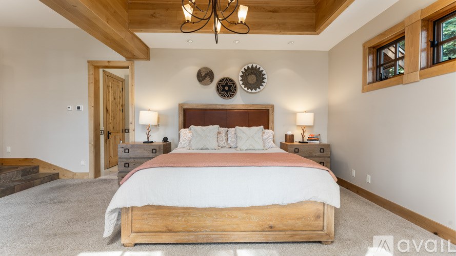A bedroom with a large bed and a chandelier.