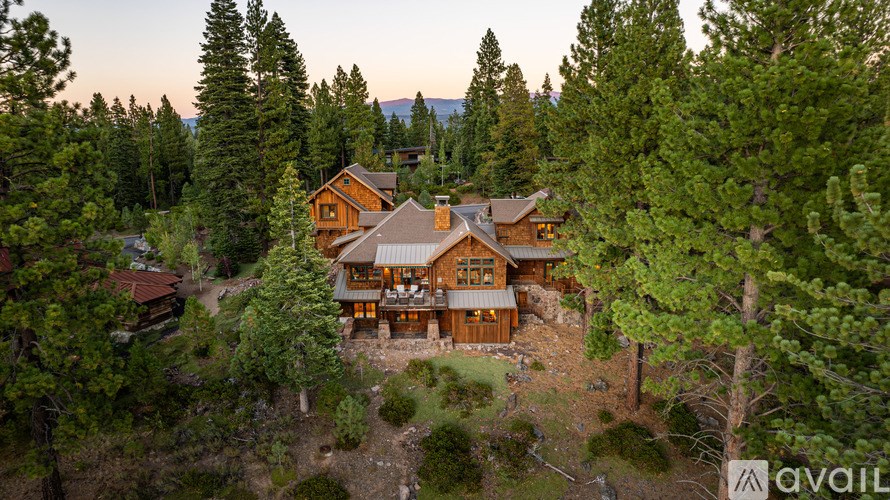 A large house surrounded by trees with the word "AVAIL" in the corner.