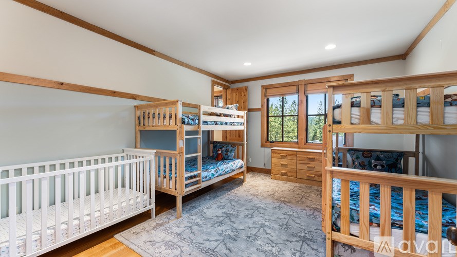 A bedroom with a white crib and two bunk beds.