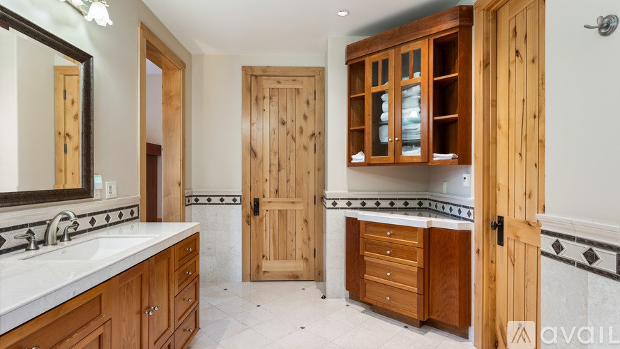 A bathroom with wooden cabinets and a marble countertop.