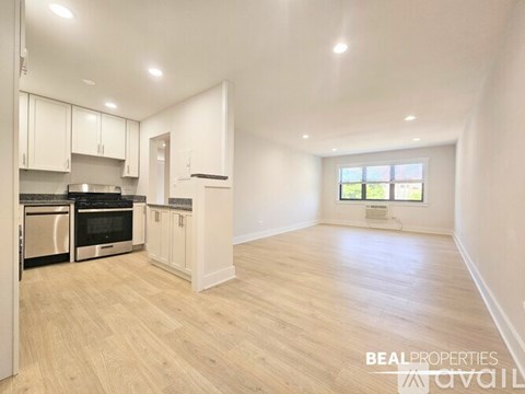 A spacious kitchen with white cabinets and stainless steel appliances.