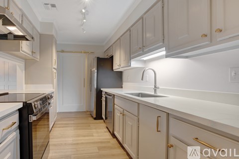A kitchen with white cabinets and a black oven.