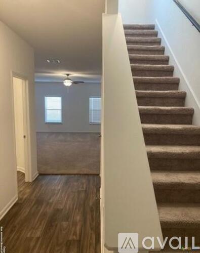 A staircase with a carpeted runner and wooden steps leads up to a second floor.