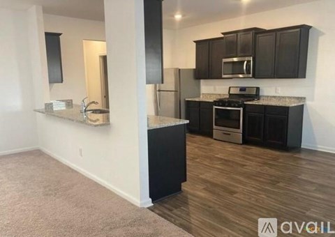 A kitchen with dark wood cabinets and a white wall.