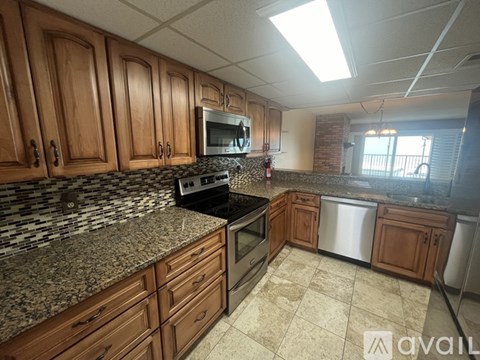 A kitchen with wooden cabinets and granite countertops.