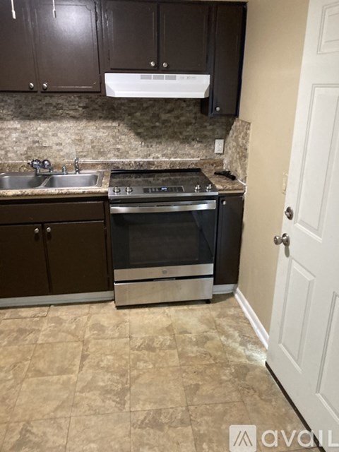 A kitchen with a stove top oven and a sink.