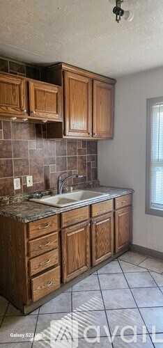 A kitchen with brown cabinets and a tiled backsplash.