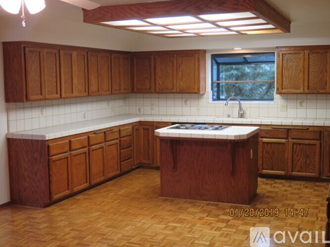 A kitchen with wooden cabinets and a tiled backsplash.