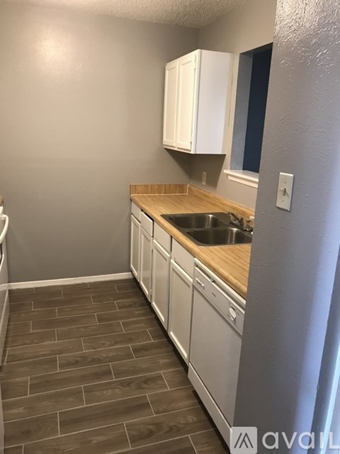 A kitchen with white cabinets and a wooden countertop.
