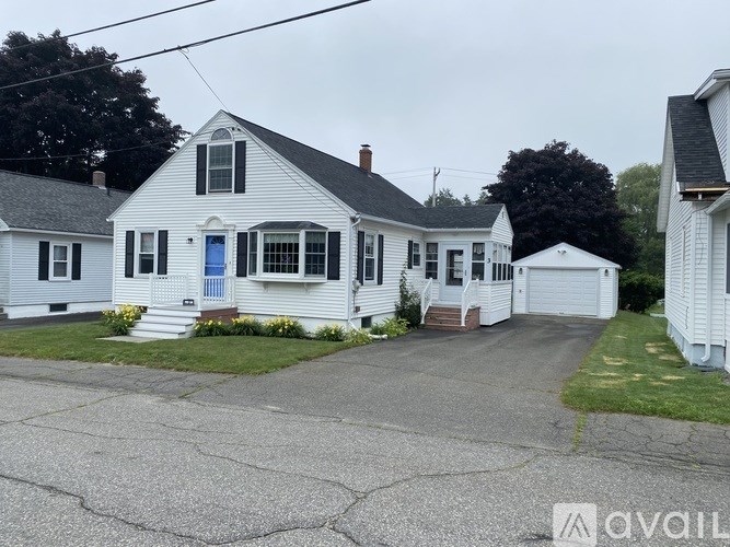 A white house with a blue door is for sale.