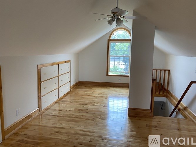 A room with wooden floors and a ceiling fan.