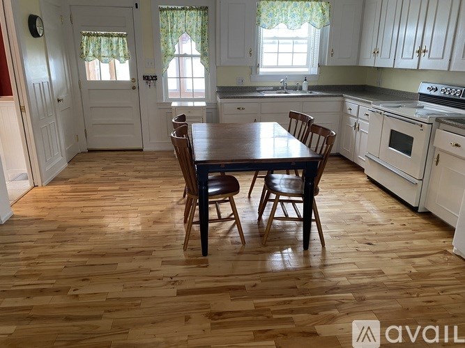 A kitchen with a table and chairs in the middle of the room.