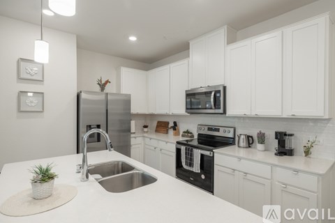 A modern kitchen with white cabinets and stainless steel appliances.