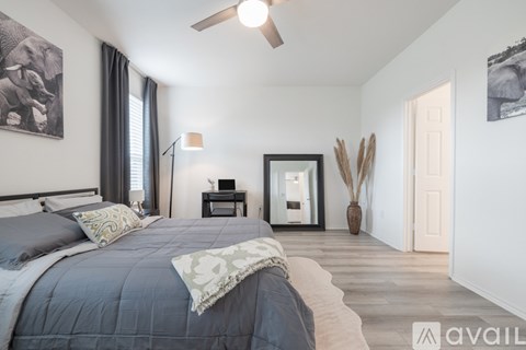 A bedroom with a large bed and a ceiling fan.