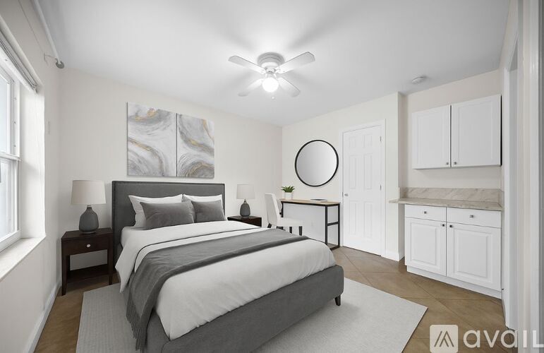 A bedroom with a large bed and a ceiling fan.