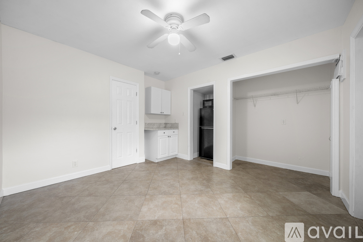 A room with a ceiling fan and a doorway leading to another room.