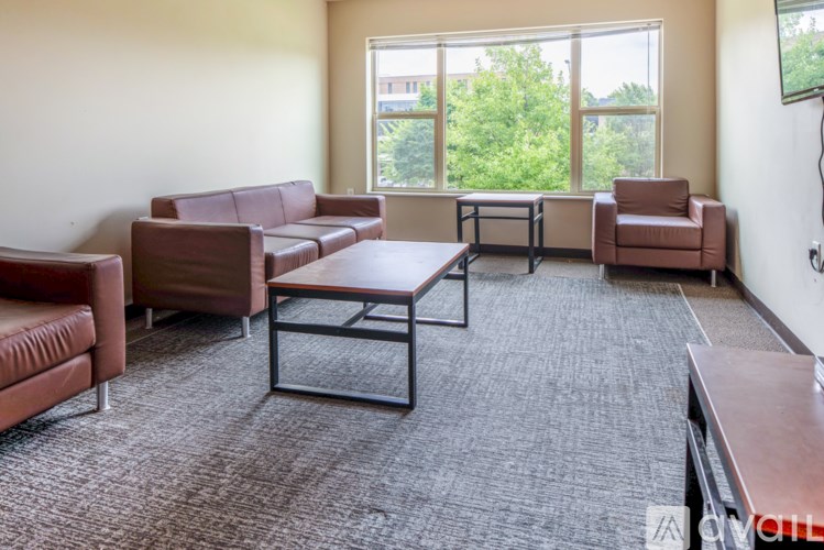 A living room with brown furniture and a large window.