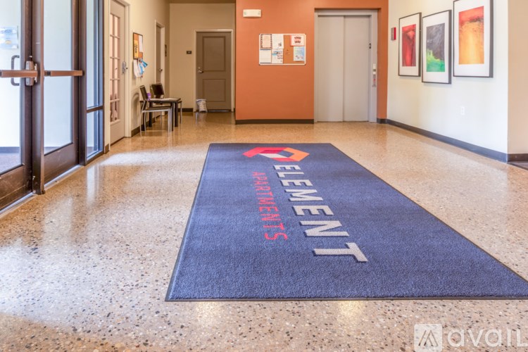 A hallway with a blue carpet that says "Element" on it.