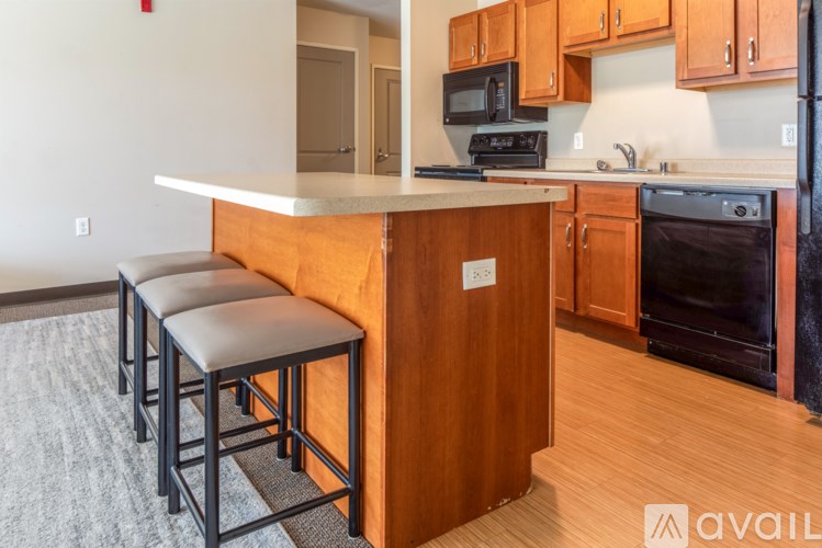 A kitchen with a white counter top and wooden cabinets.