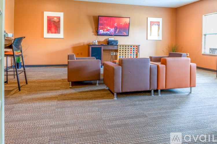 A living room with a brown sofa, a brown chair, and a brown ottoman.