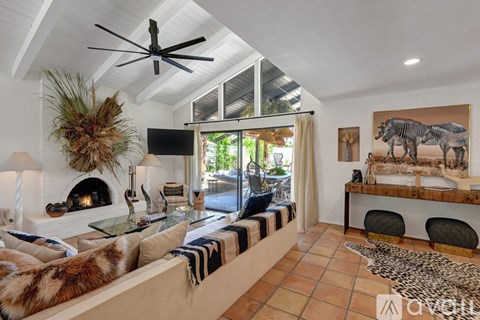 A living room with a white couch and a glass table.