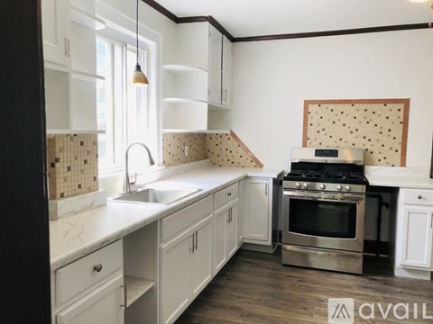 A kitchen with white cabinets and a black counter top.